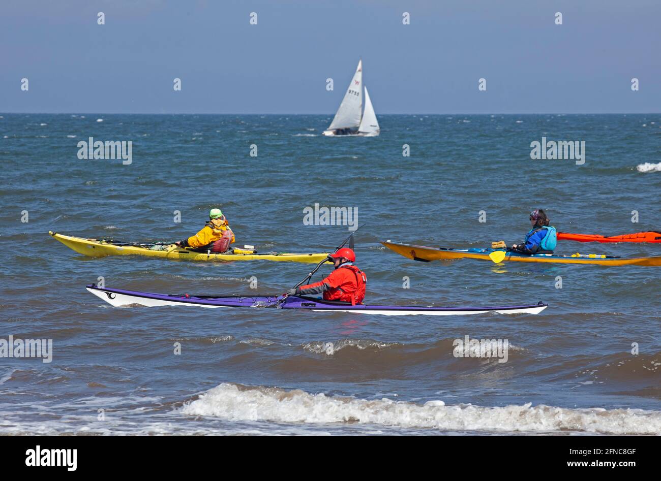 Portobello, Édimbourg, Écosse, météo britannique. 16 mai 2021. Après-midi brillant et terne, avec une température de 12 degrés au bord de la mer relativement animé. Photo : mâles et femelles en kayaks colorés sur Firth of Forth avec un petit yacht en arrière-plan. Crédit : Arch White/Alamy Live News. Banque D'Images