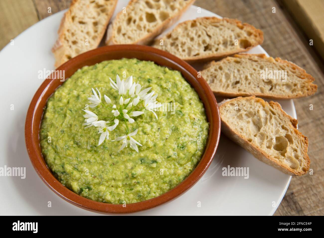 Houmous faits maison qui a été fait avec des feuilles d'ail sauvage, Allium ursinum, pois chiches en conserve, jus de citron, graines de sésame grillées et écrasées, sel, pe Banque D'Images