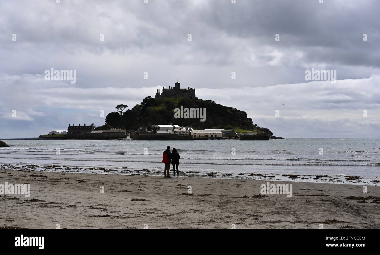 Scène romantique avec un couple qui regarde le mont St Michael's à Cornwall, Angleterre, île unique Banque D'Images