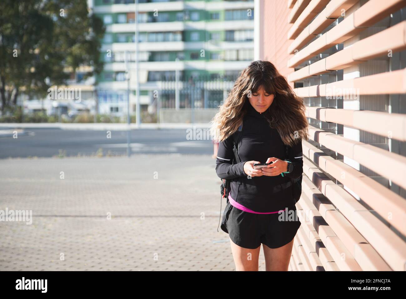 Femme sportive méconnue utilisant le téléphone après avoir fait de l'exercice à l'extérieur. Belle femme. Concept sport Banque D'Images