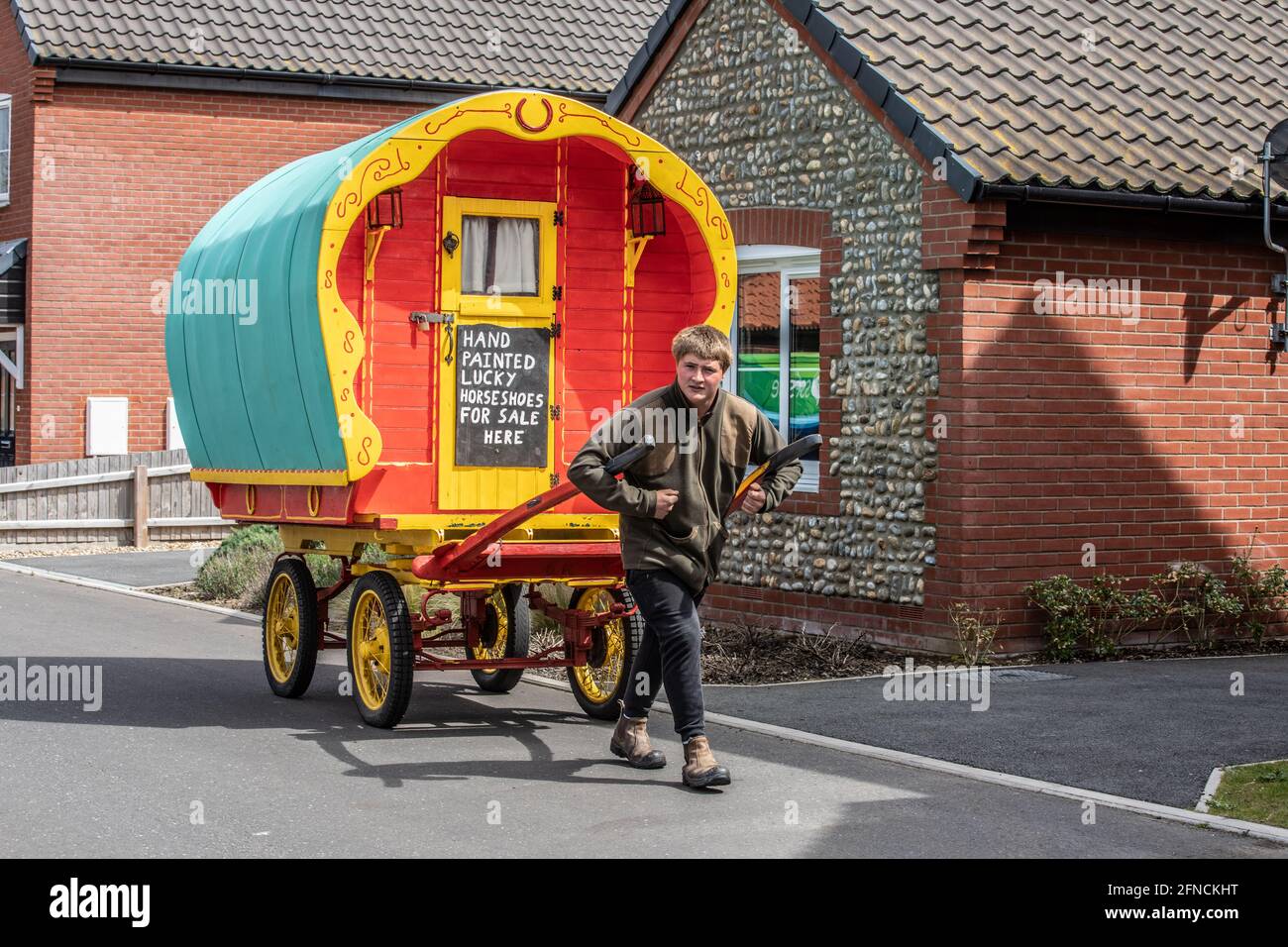 Freddy Coleman porte son ancien chariot à cheval à la recherche d'affaires vendant des fers à cheval peints à Bacton, Norfolk, Angleterre, Royaume-Uni Banque D'Images