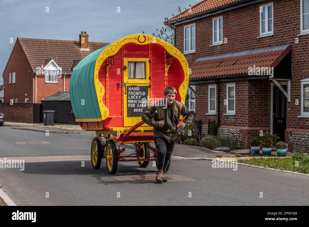 Freddy Coleman porte son ancien chariot à cheval à la recherche d'affaires vendant des fers à cheval peints à Bacton, Norfolk, Angleterre, Royaume-Uni Banque D'Images