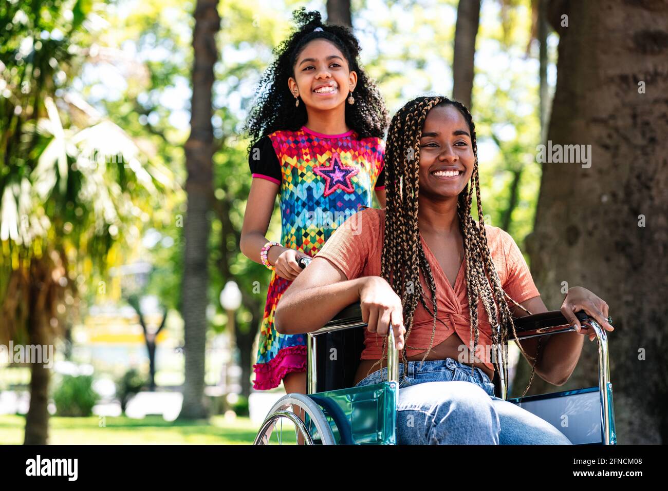 Femme en fauteuil roulant au parc avec sa fille. Banque D'Images