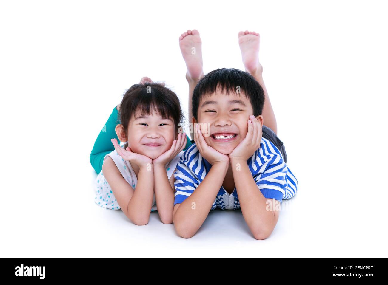Enfants asiatiques couchés sur le sol. Les enfants chinois se sont contentés et souriants, isolés sur fond blanc. Conceptuel de l'amour des frères et sœurs. Happ Banque D'Images