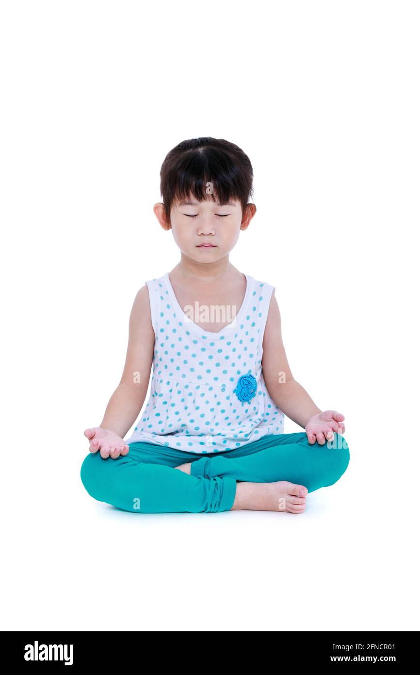 Enfant asiatique joli avec les yeux fermés et faisant des exercices de yoga dans la pose de lotus. Fille en bonne santé pratiquant la forme physique au studio. Isolé sur fond blanc. Banque D'Images