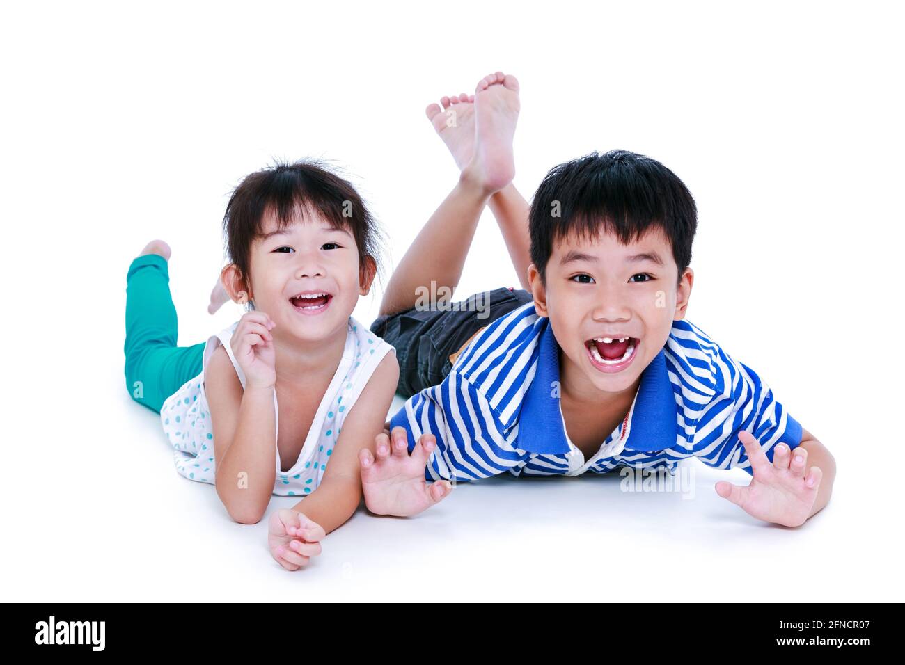 Enfants asiatiques couchés sur le sol. Les enfants chinois se sont contentés et souriants, isolés sur fond blanc. Conceptuel de l'amour des frères et sœurs. Happ Banque D'Images