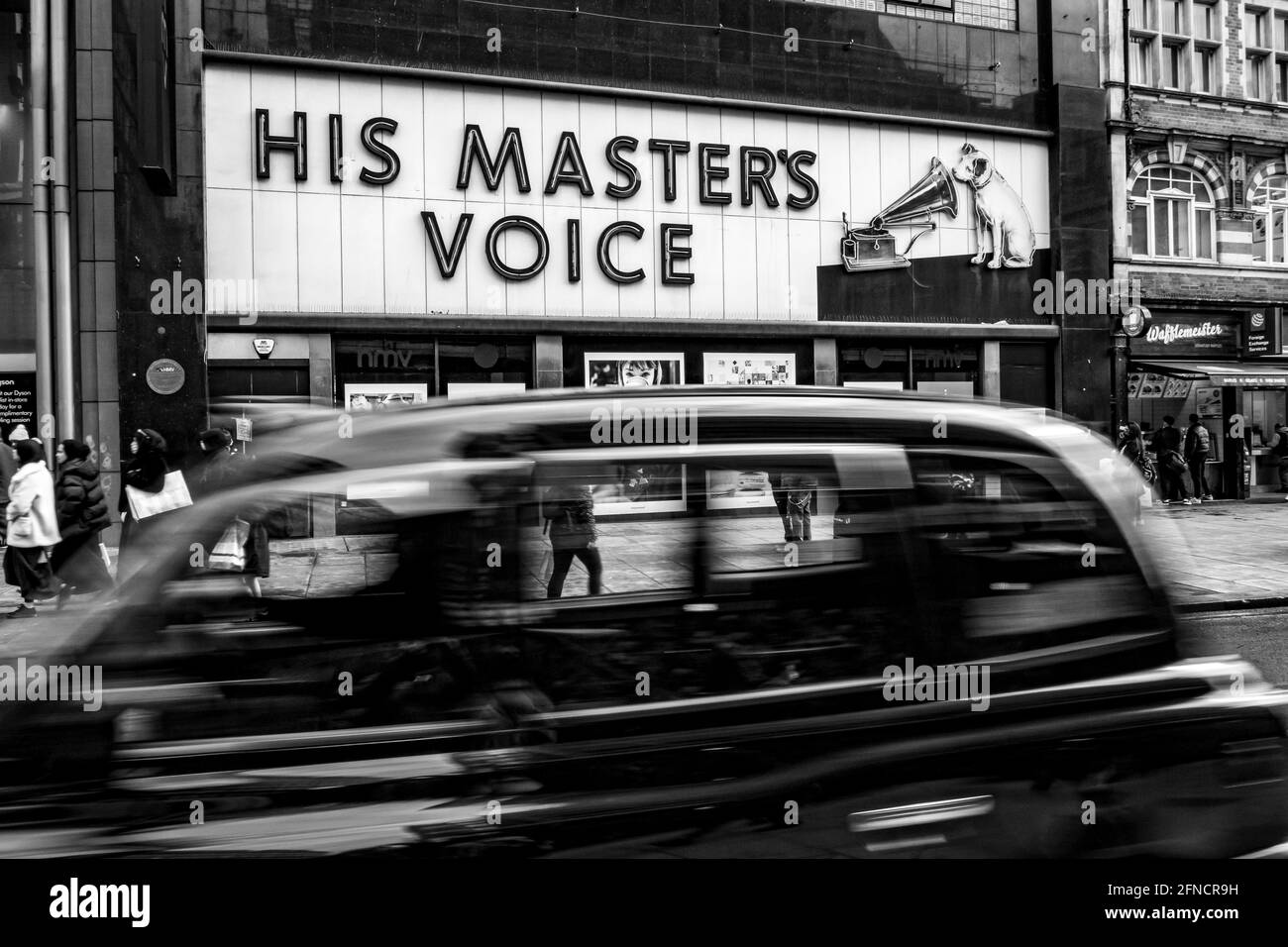 Black Cab passant par HMV dans Oxford Street avec célèbre Panneau chien et trompette Banque D'Images