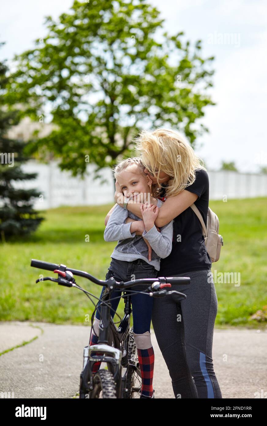 Maman et fille s'amusent sur le même vélo et se reposent dans la nature. Une adorable famille fait du vélo et amusez-vous bien Banque D'Images