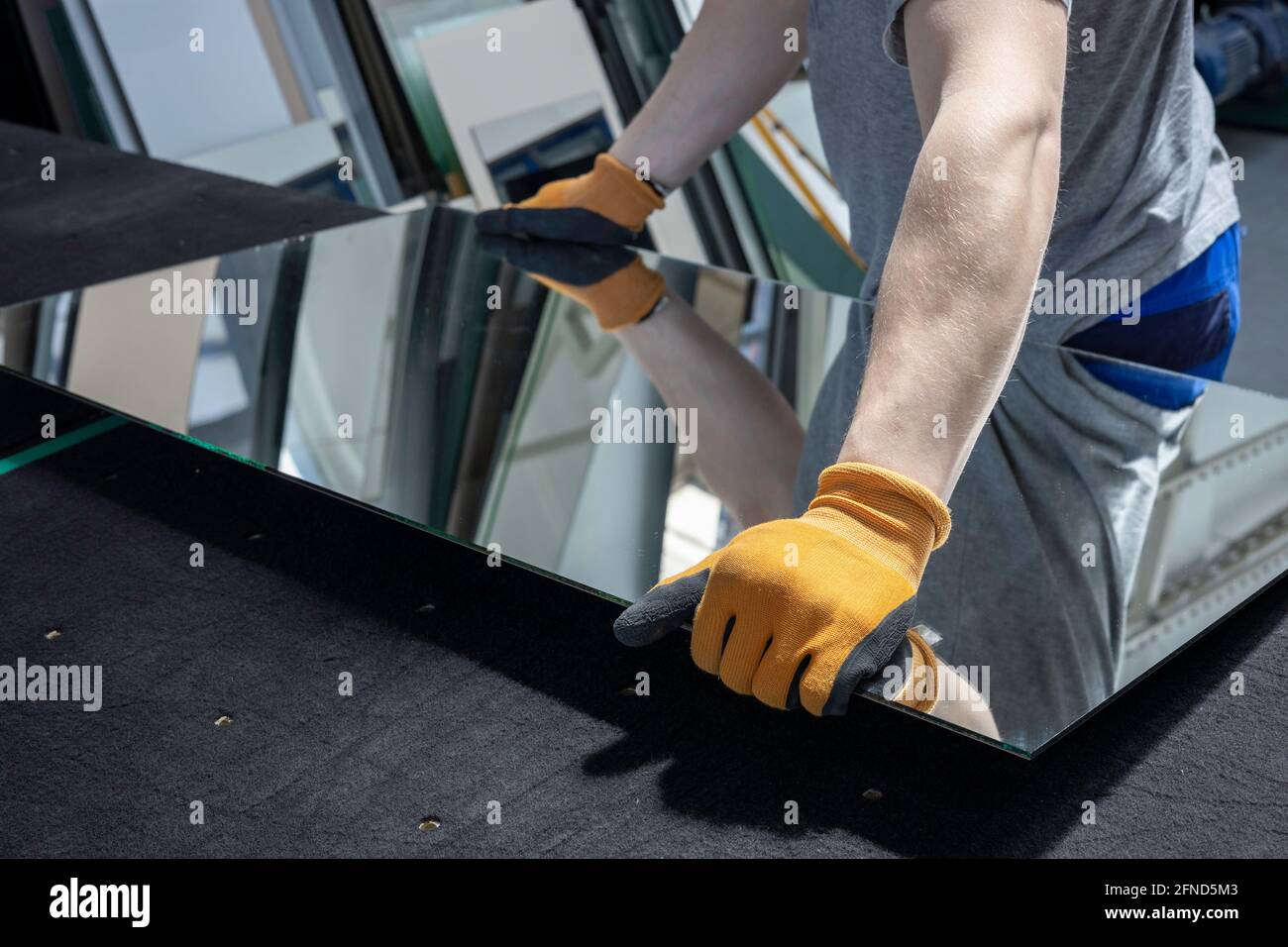 le vitrier ramasse le miroir de la table dans l'usine de verre Banque D'Images