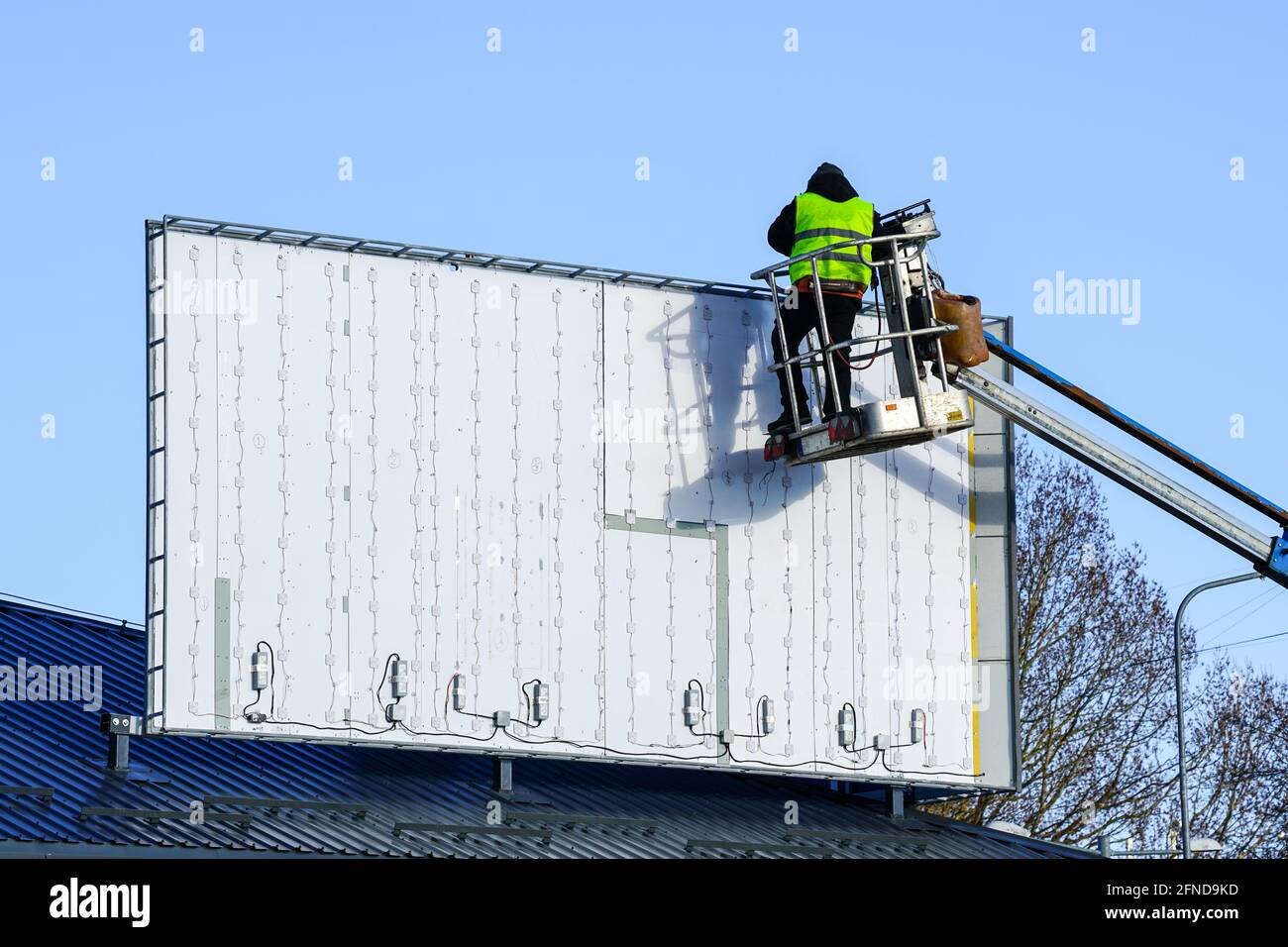 Installation d'un nouveau grand panneau d'affichage moderne avec éclairage LED sur fond de ciel bleu Banque D'Images