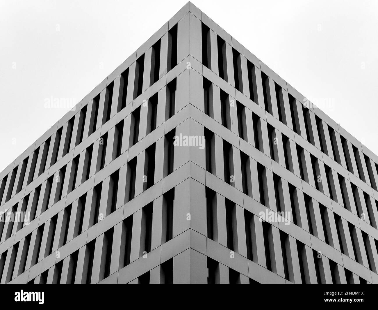 Un petit angle de l'angle d'un bâtiment moderne contre le ciel blanc Banque D'Images