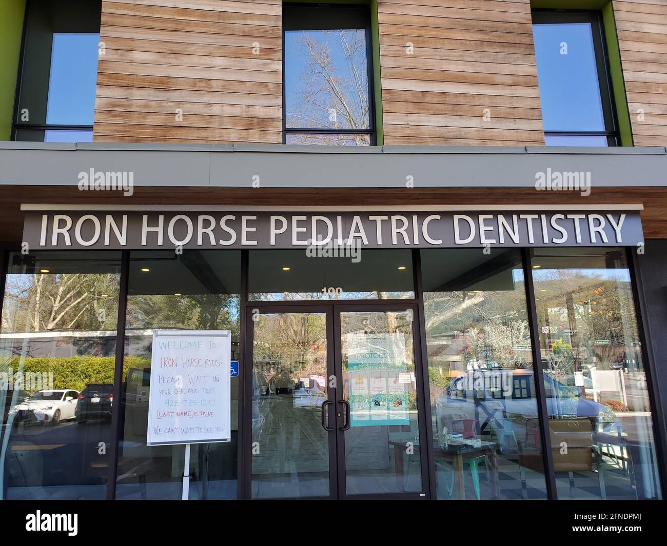 Photographie de la façade dentaire pédiatrique Iron Horse, avec un panneau COVID-19 demandant aux patients d'attendre dans leur voiture et du texte pour être admis, à Danville, Californie, le 20 mars 2021. () Banque D'Images