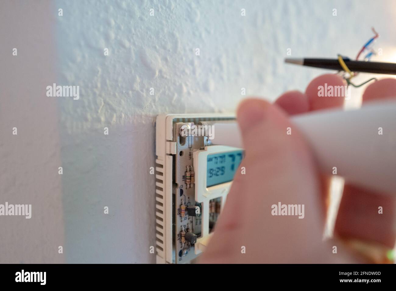 Fixation de fils codés lors de l'installation de Google Nest Learning thermostat lors d'un projet de rénovation de maison intelligente à Lafayette, Californie, le 17 janvier 2021. () Banque D'Images