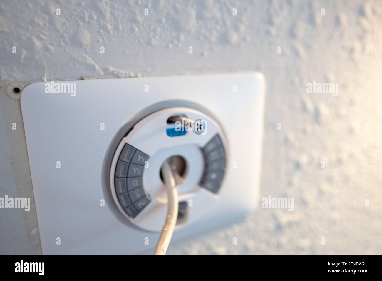 Fixation de la plaque avant lors de l'installation de Google Nest Learning thermostat lors d'un projet de rénovation de maison intelligente à Lafayette, Californie, le 17 janvier 2021. () Banque D'Images