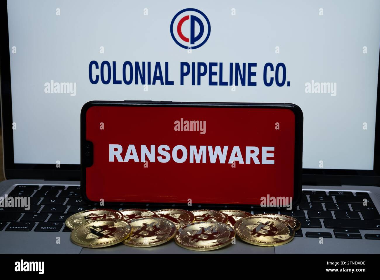 Colonial Pipeline Co logo sur l'arrière-plan flou et le mot RANSOMWARE sur le smartphone à l'avant. Stafford, Royaume-Uni, 16 mai 2021. Banque D'Images
