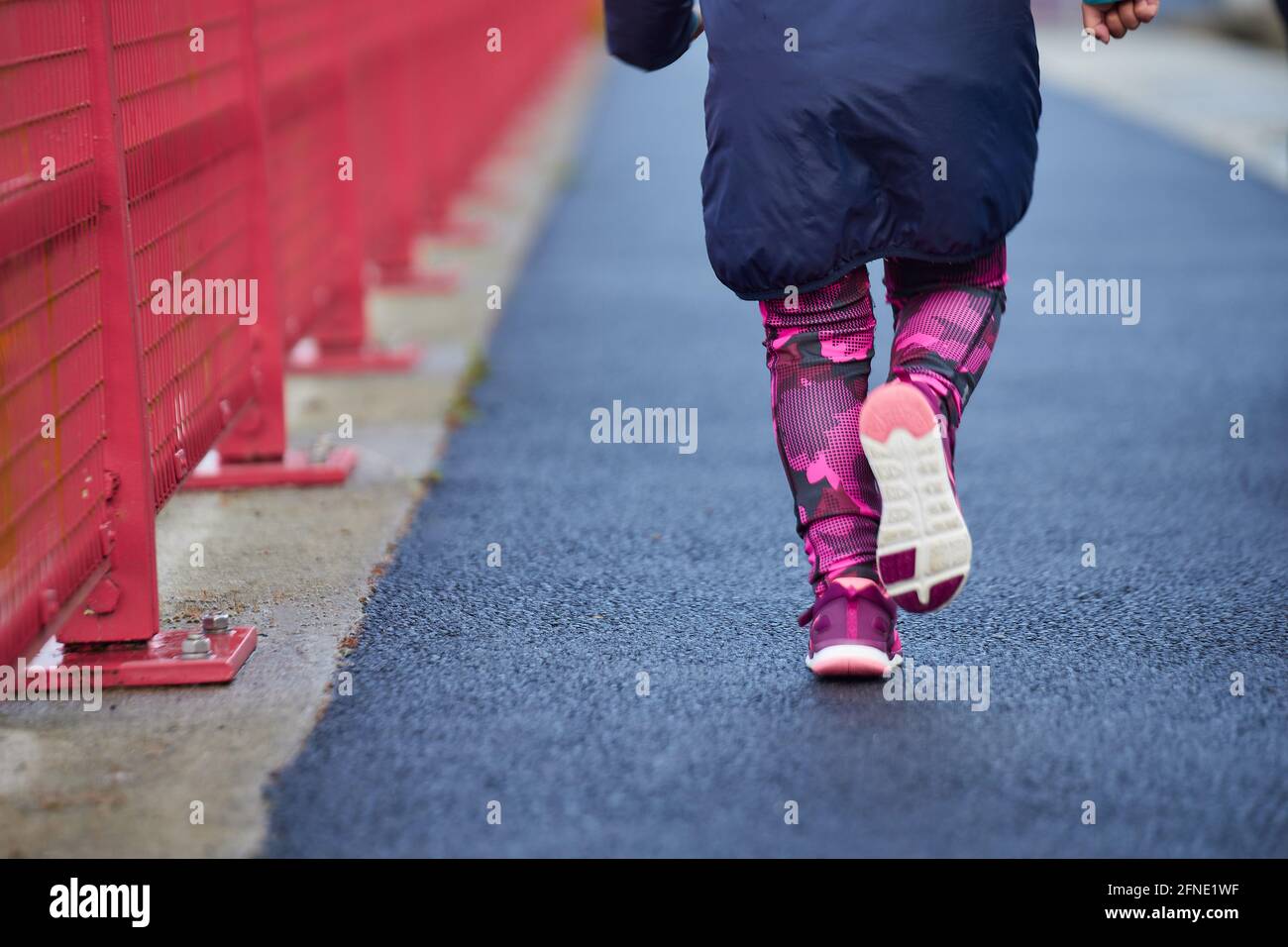 fille athlète de sport courant jeune dans la course pour garçons, courir dans les détails de la ville sur ses jambes Banque D'Images