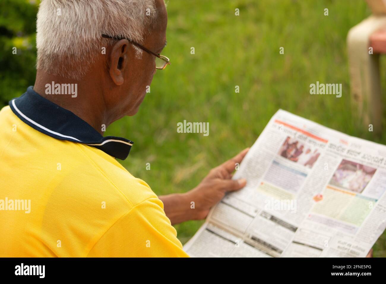 Focus sur l'épaule, épaule photo d'un vieil homme occupé à lire le journal de nouvelles du matin - concept de personnes âgées matin style de vie quotidien. Banque D'Images