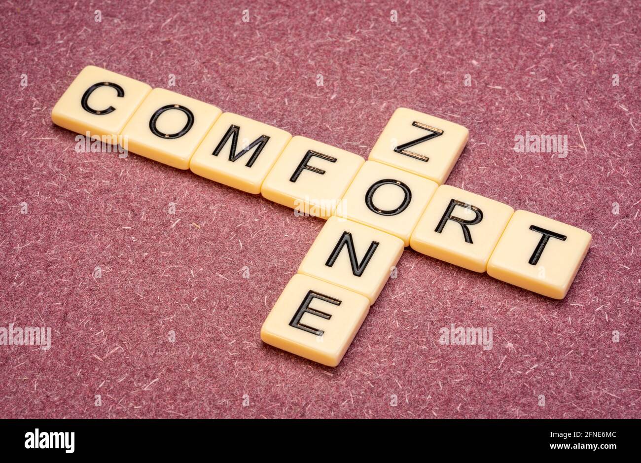 la zone de confort crossword en carreaux de lettre ivoire contre papier texturé fait à la main, un état psychologique dans lequel les choses se sentent familières Banque D'Images