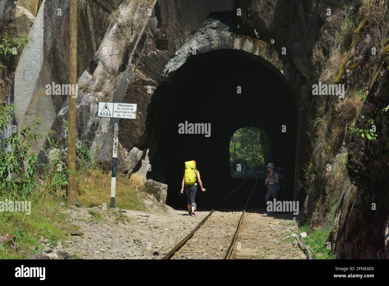 Touristes avec sac à dos dans le tunnel du chemin de fer à Cusco, signe passage pour piétons interdit, Machu Picchu, province Urubamba, Pérou Banque D'Images