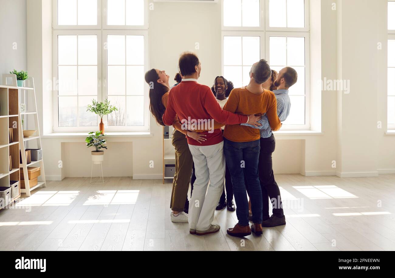 Une équipe de gens heureux et variés qui se mêlent, rient et s'amusent dans un bureau moderne Banque D'Images