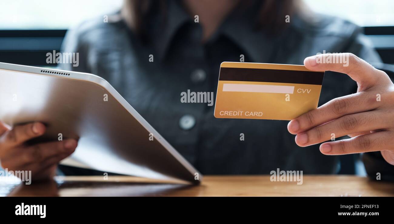 Femme aime avec l'application d'achat en ligne et regardant le crédit carte pour le numéro de remplissage à payer Banque D'Images