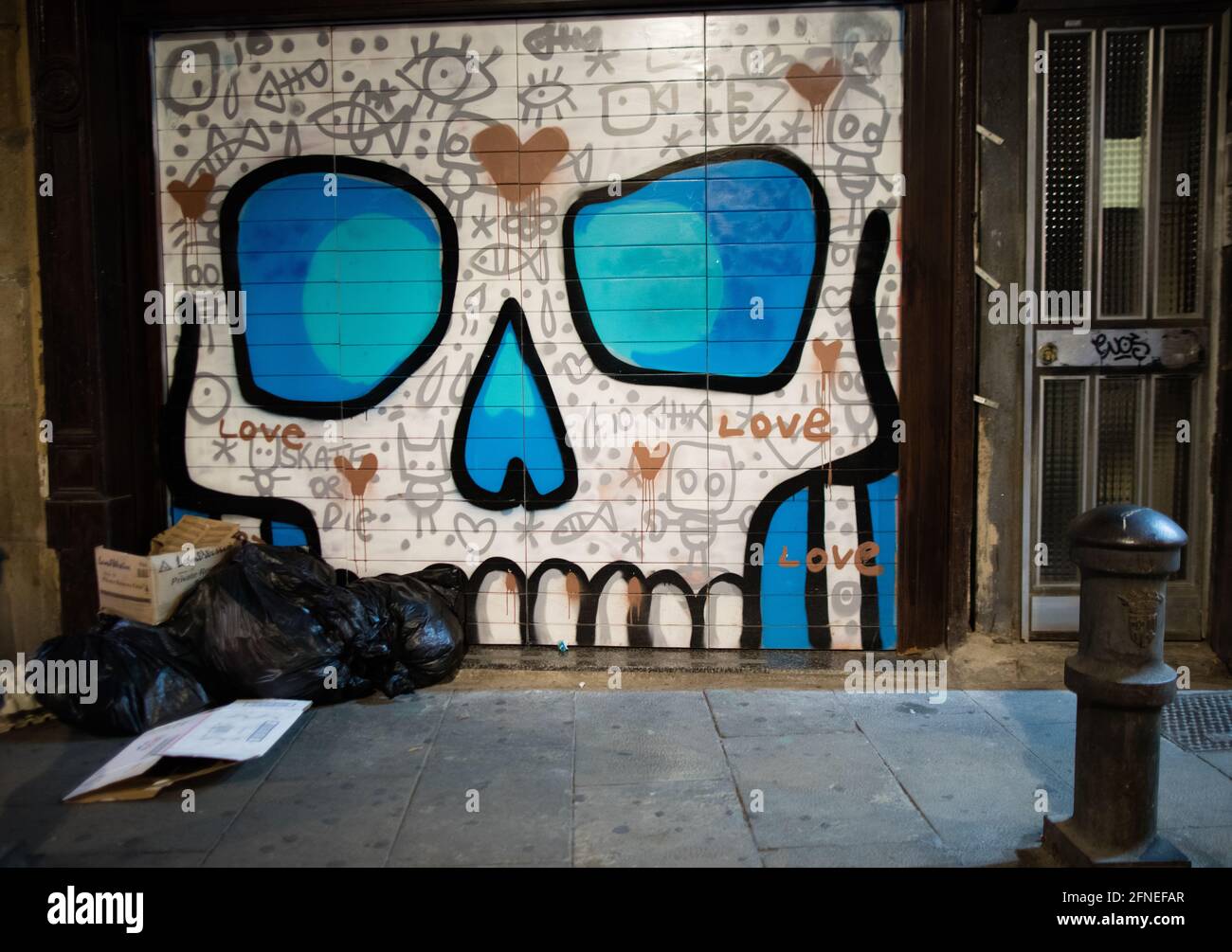 Des œuvres d'art colorées ornent les portes de la façade de la boutique après la fermeture de nuit dans le quartier gothique de Barcelone, en Espagne Banque D'Images