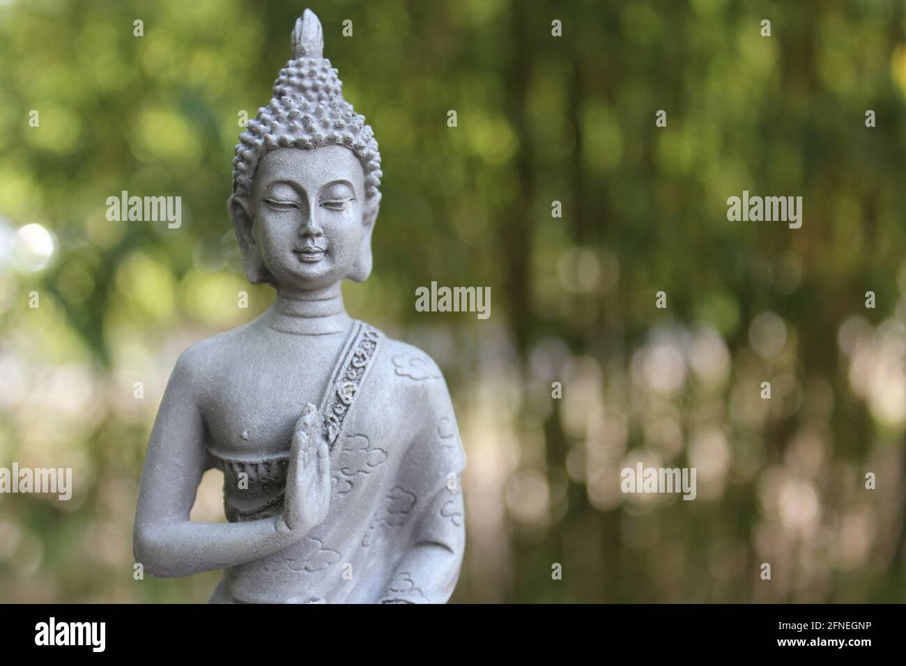 Statue de Bouddha à l'extérieur dans le jardin avec un arrière-plan flou Banque D'Images