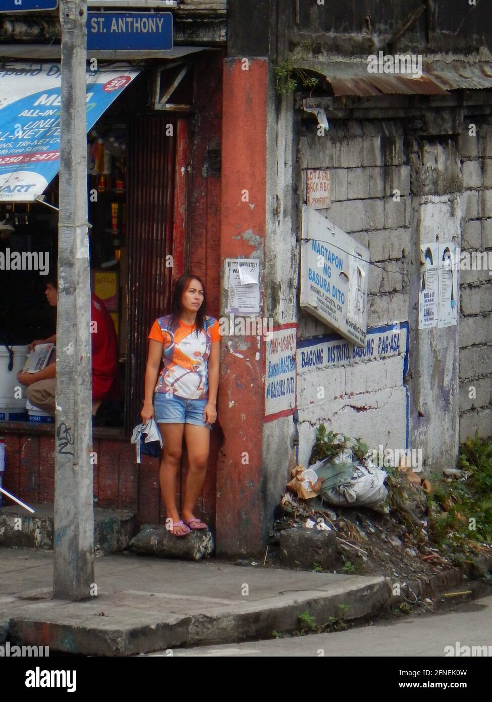 Jeune femme philippine asiatique debout à un coin de rue à Novaliches, Manille, Philippines Banque D'Images