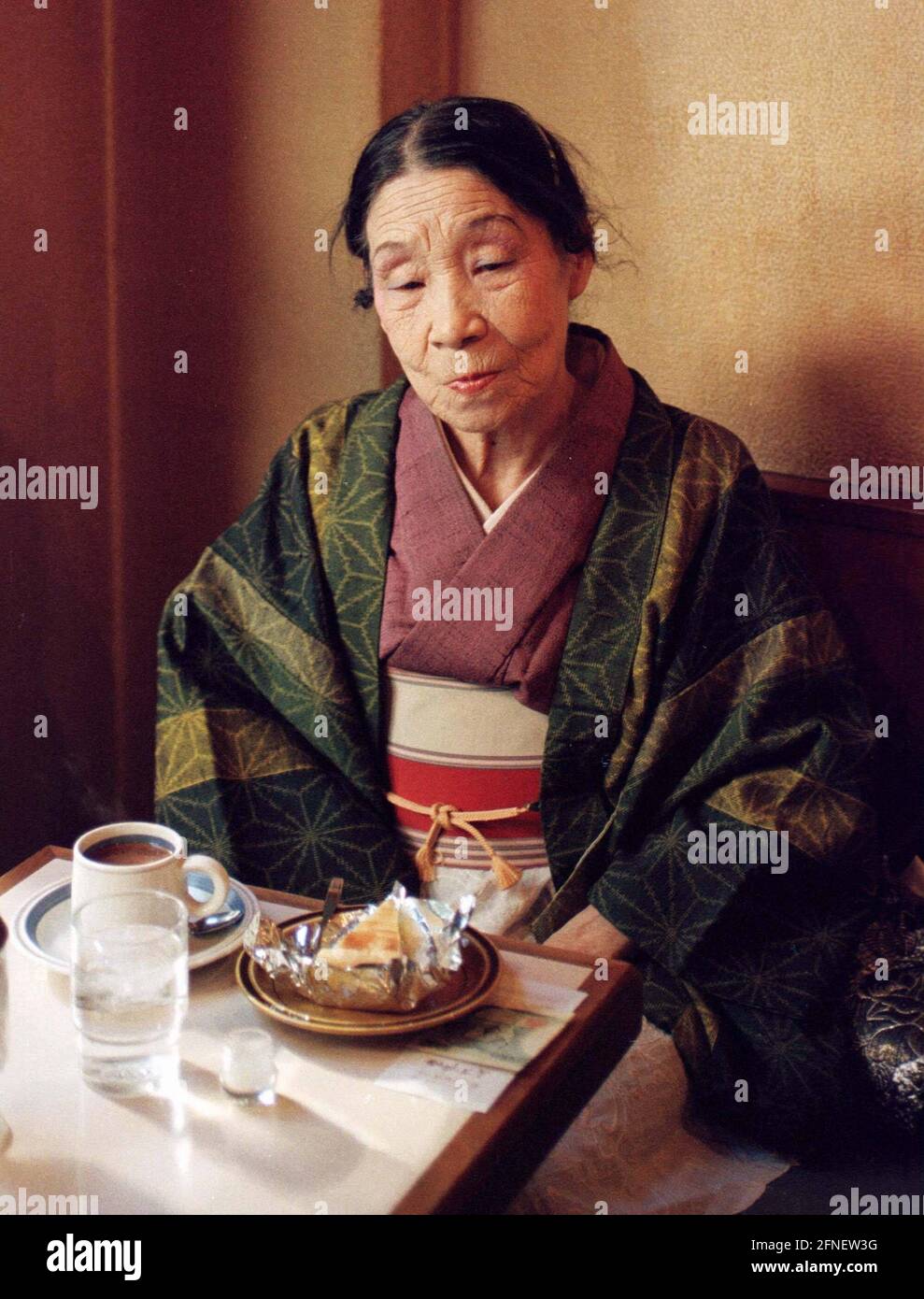 Une femme plus âgée dans un kimono mangeant dans un restaurant. [traduction automatique] Banque D'Images