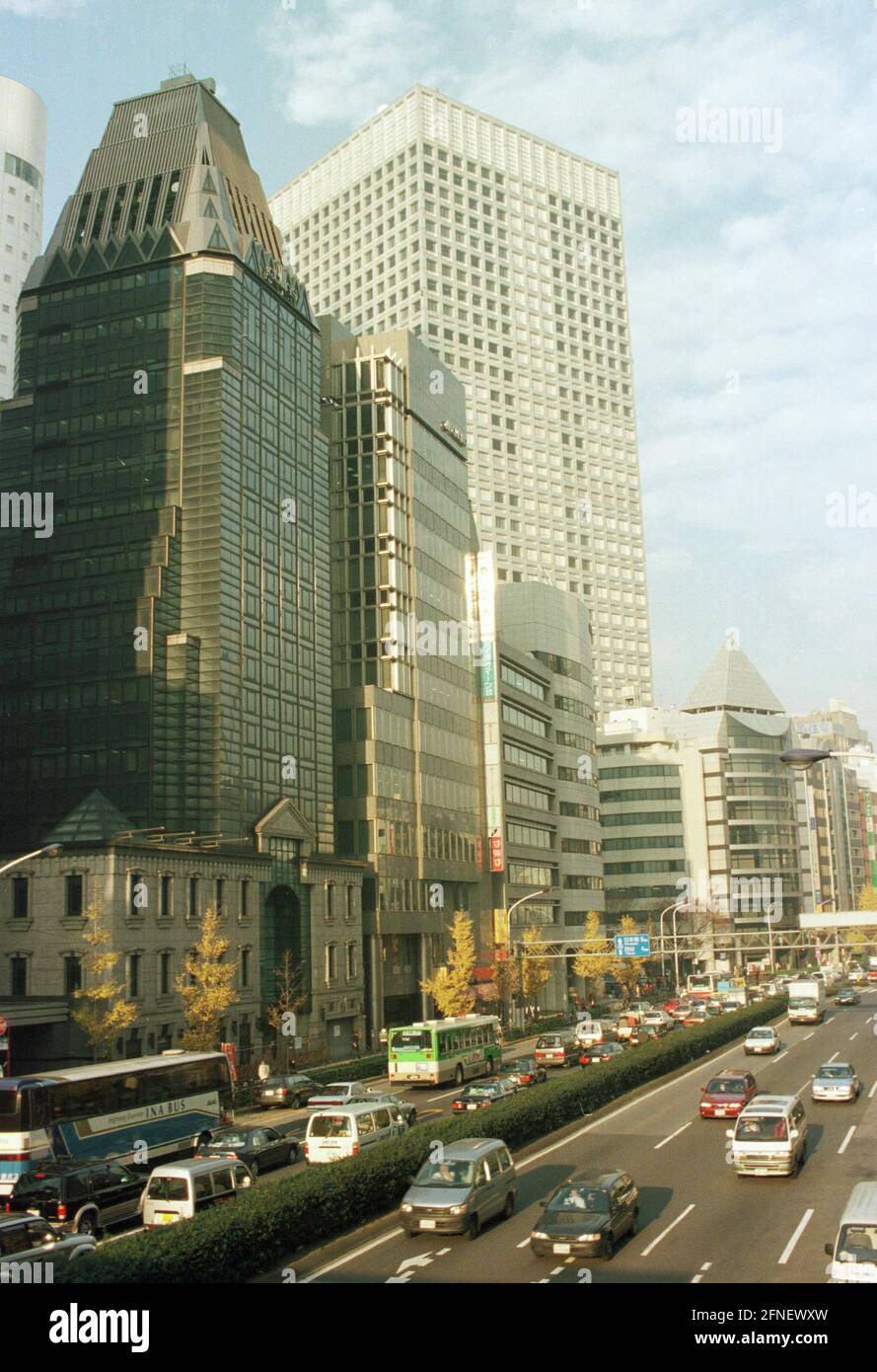 Des gratte-ciels bordent une rue animée du quartier Shinjuku de Tokyo. [traduction automatique] Banque D'Images