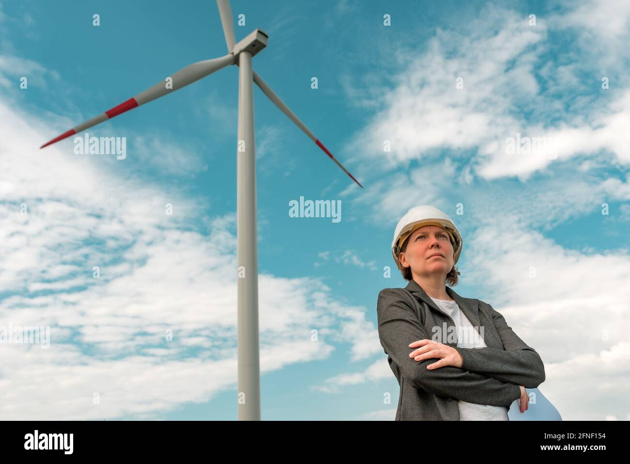 Portrait d'une femme ingénieur sur une ferme éolienne moderne pendant la planification du projet d'entretien Banque D'Images