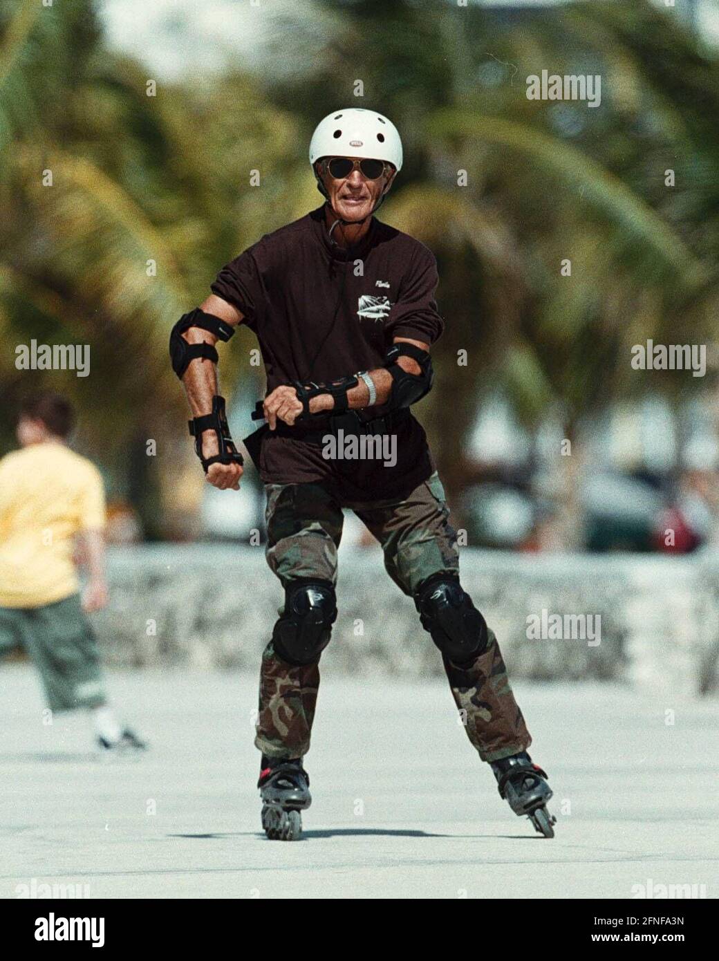 Un homme plus âgé portant des protège-coudes, des protège-genoux et un  casque roule sur ses rollers sur la promenade de Miami Beach. [traduction  automatique] Photo Stock - Alamy