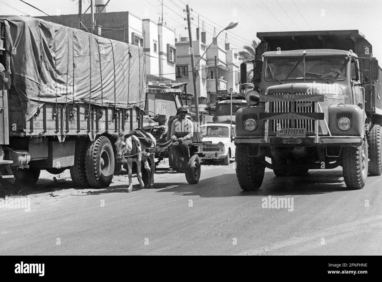 Trafic à Gaza. Entre les voitures et les camions, il y a un chariot à âne traditionnel. [traduction automatique] Banque D'Images