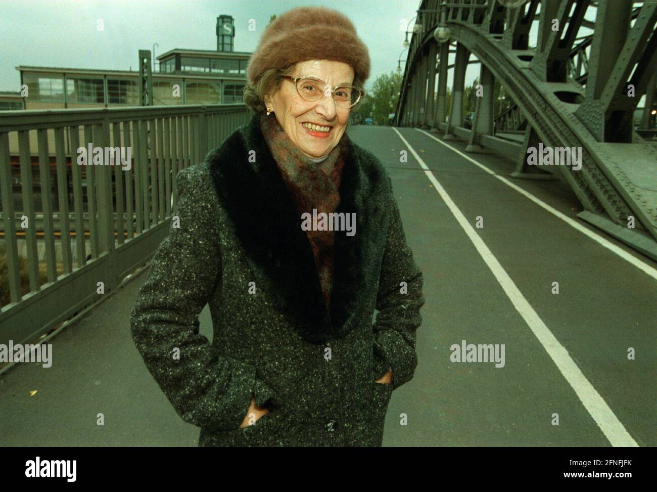 Mme Margarete Behm, sur le Boesebruecke (ancien pont Hindenburg) où se trouvait le poste frontalier de Bornholmer Strasse avant la chute du mur, s'est dirigée vers le poste frontalier de Bornholmer Strasse le 9 novembre 1989, lorsqu'elle a entendu parler de l'ouverture du mur le soir, Portant une chemise de nuit et un manteau, et traversé la frontière vers Berlin Ouest, DEU, Berlin-Prenzlauer Berg, 27 octobre 1999, [traduction automatique] Banque D'Images