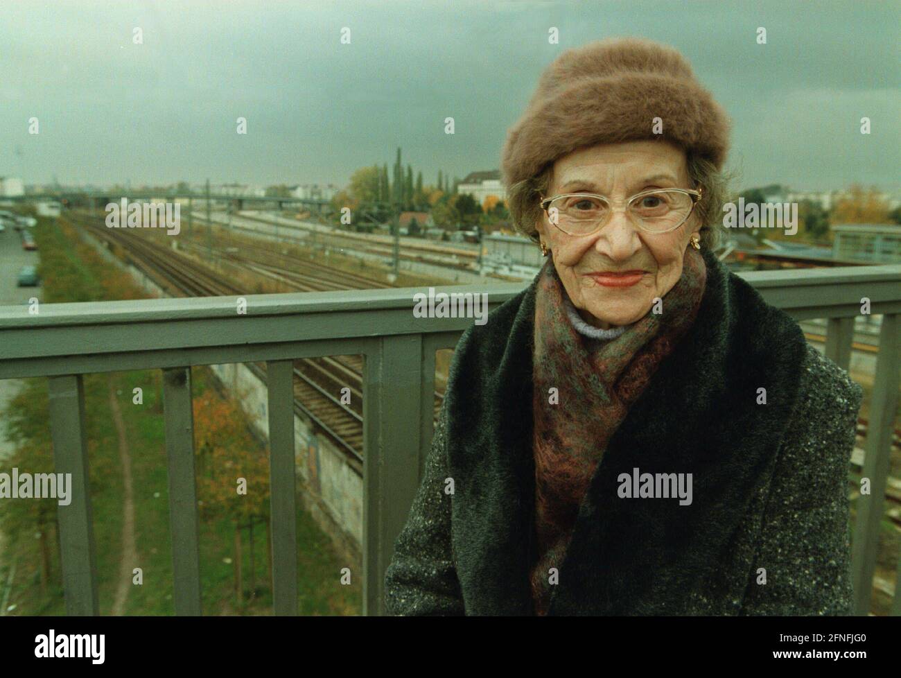 Mme Margarete Behm, sur le Boesebruecke (ancien pont Hindenburg) où se trouvait le poste frontalier de Bornholmer Strasse avant la chute du mur, s'est dirigée vers le poste frontalier de Bornholmer Strasse le 9 novembre 1989, lorsqu'elle a entendu parler de l'ouverture du mur le soir, Portant une chemise de nuit et un manteau, et traversé la frontière vers Berlin Ouest, DEU, Berlin-Prenzlauer Berg, 27 octobre 1999, [traduction automatique] Banque D'Images