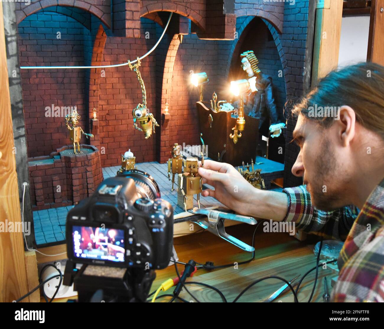 15 mai 2021, Saxe, Leipzig: Valentin Felder, étudiant en informatique et cinéaste de Leipzig, prépare des accessoires miniatures dans son petit studio pour son film d'une demi-heure "Gears in the Sand". Ce projet, qui date de 27 ans, met en scène des hommes sans cœur et des robots sensibles dans une histoire imaginative, des milliers de pièces de 0.5 à quelques centimètres en cuivre, laiton, bois, acier, plâtre ou polystyrène ont déjà été transformées, déposées, soudé et fraisé à cette fin, entre autres pour ses robots et machines. Il documente le développement Banque D'Images