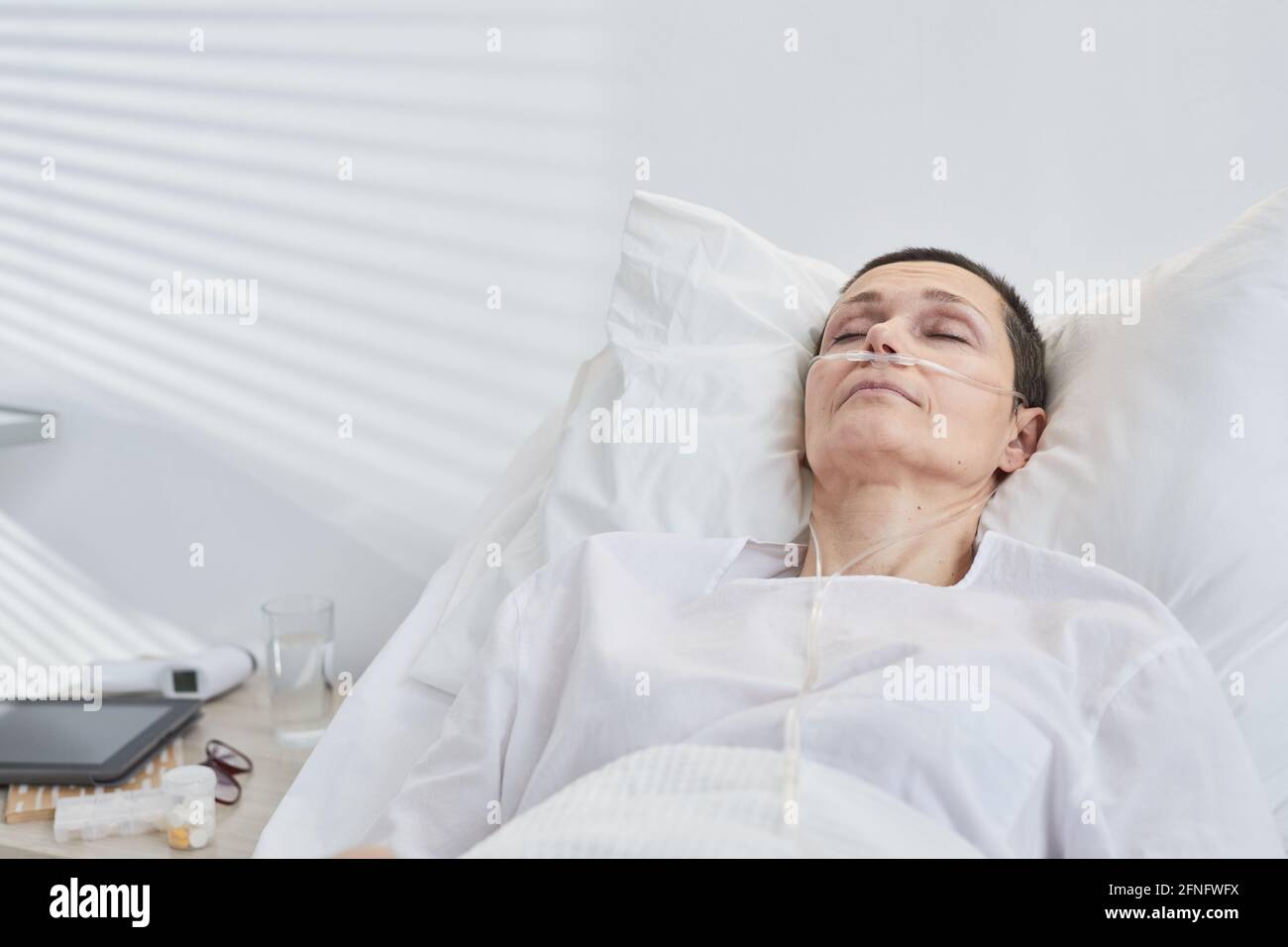 Femme sénichée au lit avec un compte-gouttes à l'hôpital quartier Banque D'Images