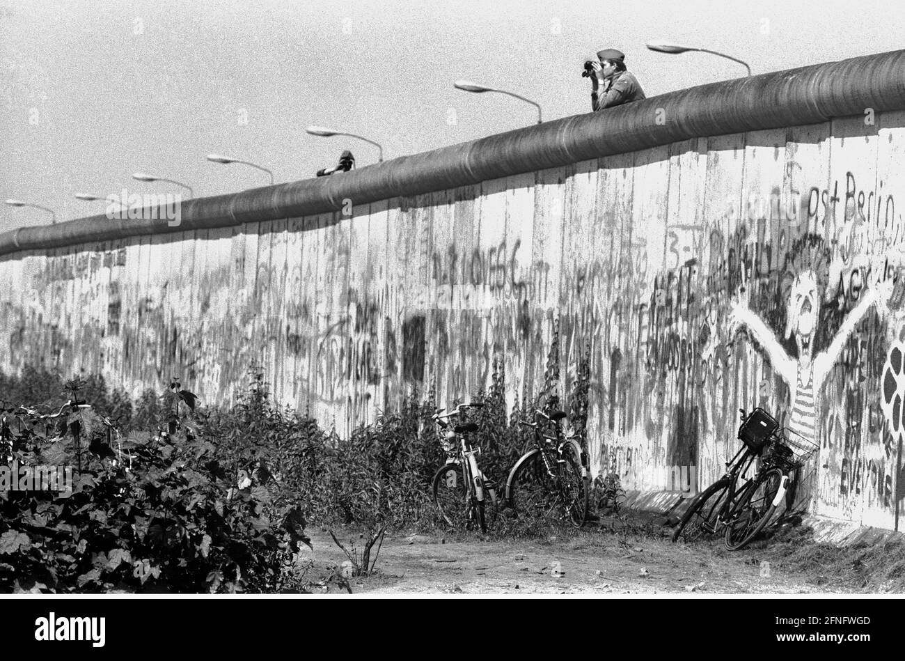 Berlin / Tiergarten / Mitte / GDR / 6 / 1988 les gardes-frontières GDR donnent sur le mur en direction de Berlin-Ouest. Là, les jeunes ont occupé une partie de la terre d'aucun homme. Elle est en Occident, mais appartient à l'est. La police de Berlin-Ouest est en train de la nettoyer. // Potsdamer Platz / Histoire / communisme / districts [traduction automatique] Banque D'Images