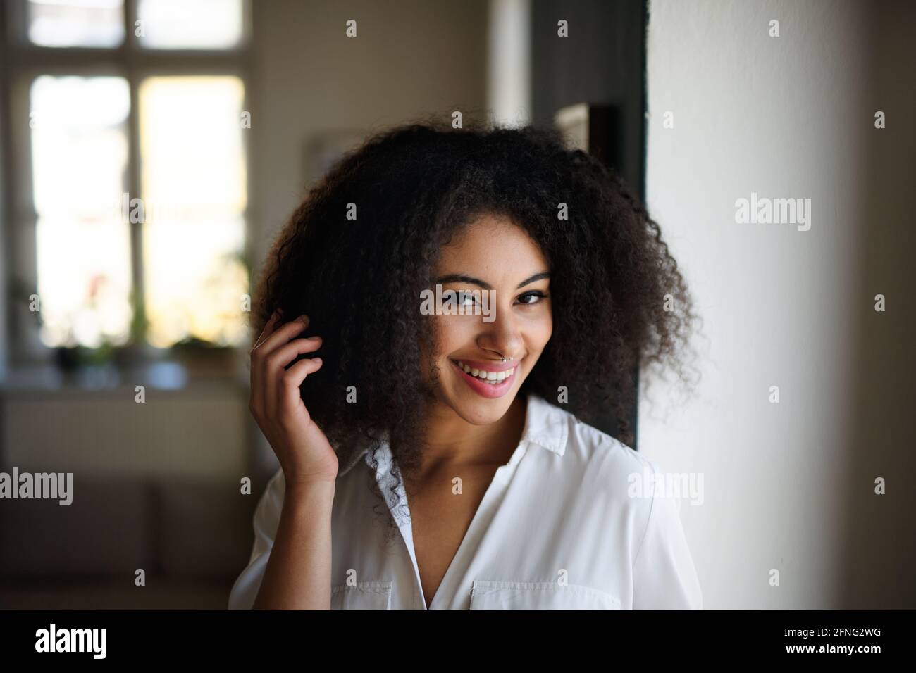 Portrait en gros plan d'une jeune femme à l'intérieur, regardant l'appareil photo. Banque D'Images