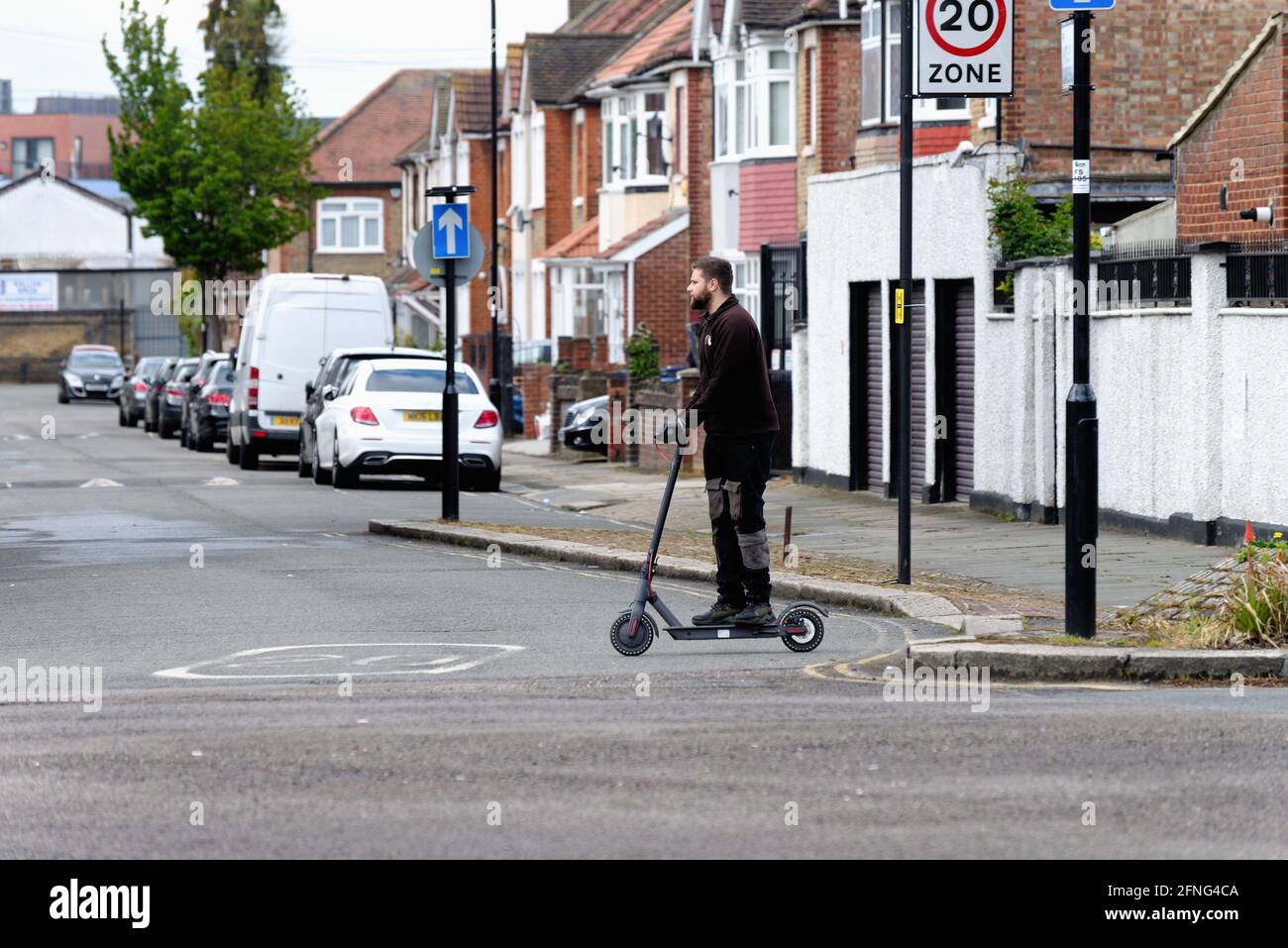 Un jeune homme blanc à bord d'un scooter électrique Road à Southall Londres Angleterre Royaume-Uni Banque D'Images