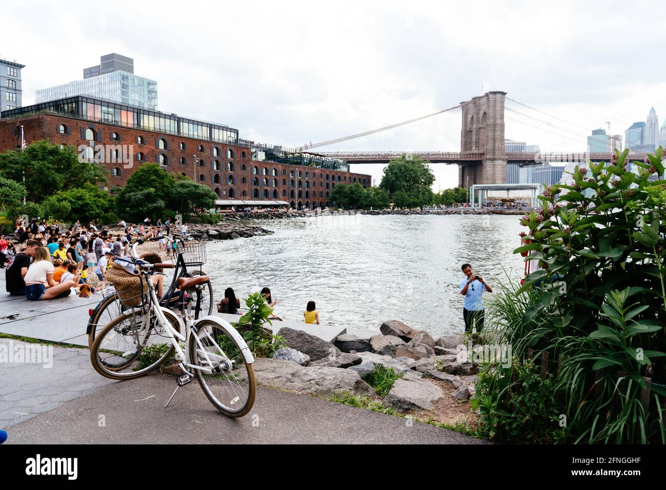 New York City, Etats-Unis - 24 juin 2018 : les gens apprécient le front de mer de la région de DUMBO à Brooklyn. Vue sur le pont aginst Broklyn et Cityscape of NYC Banque D'Images