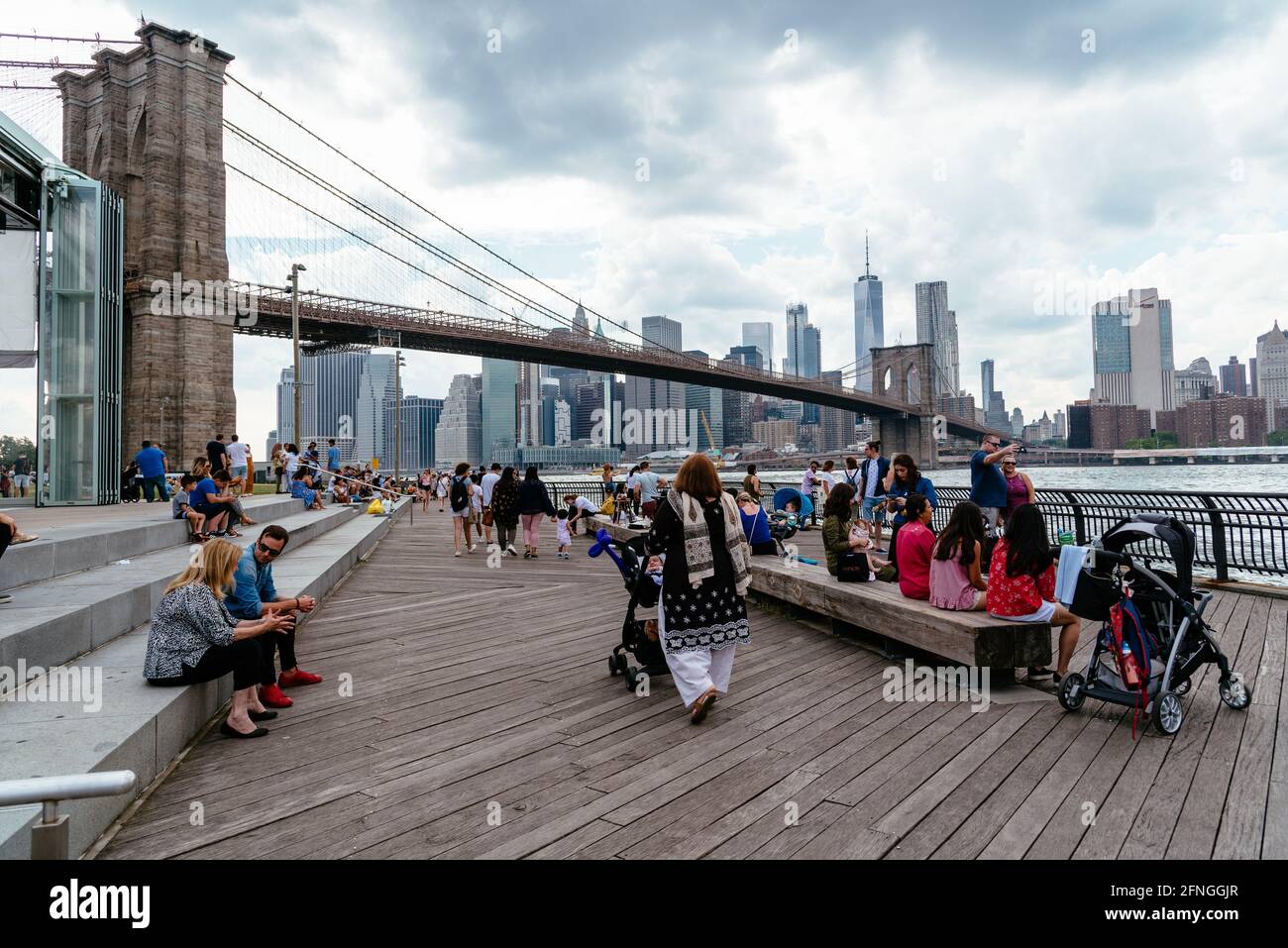 New York City, Etats-Unis - 24 juin 2018 : les gens apprécient le front de mer de la région de DUMBO à Brooklyn. Vue sur le pont aginst Broklyn et Cityscape of NYC Banque D'Images