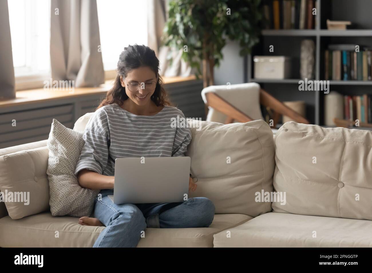 Une jeune femme heureuse travaille sur un ordinateur portable en ligne Banque D'Images