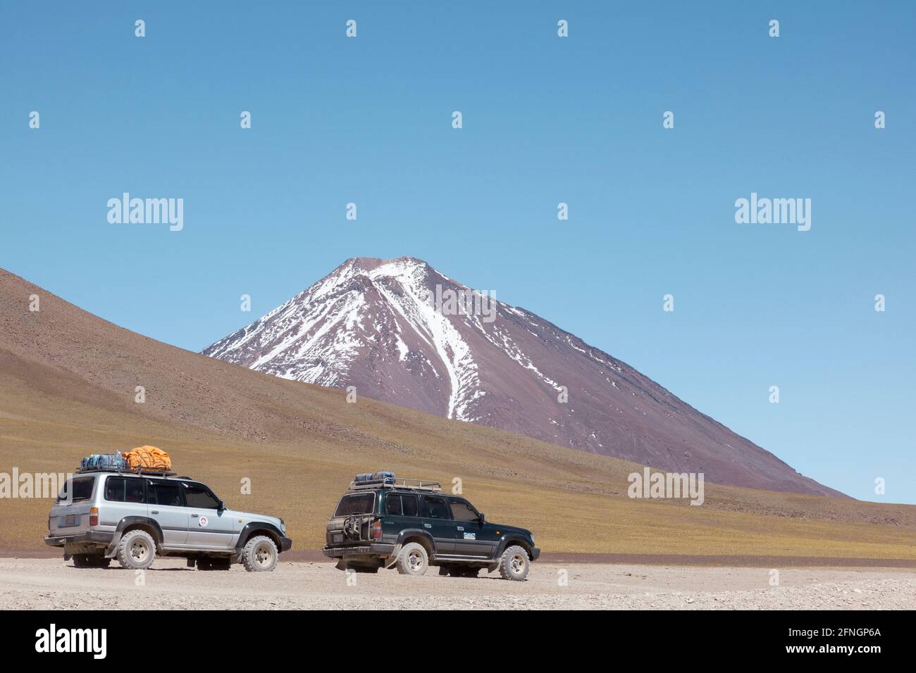 Les véhicules 4x4 de safari hors-terrain sont vus au bord de la Laguna Verde dans le désert bolivien. Banque D'Images