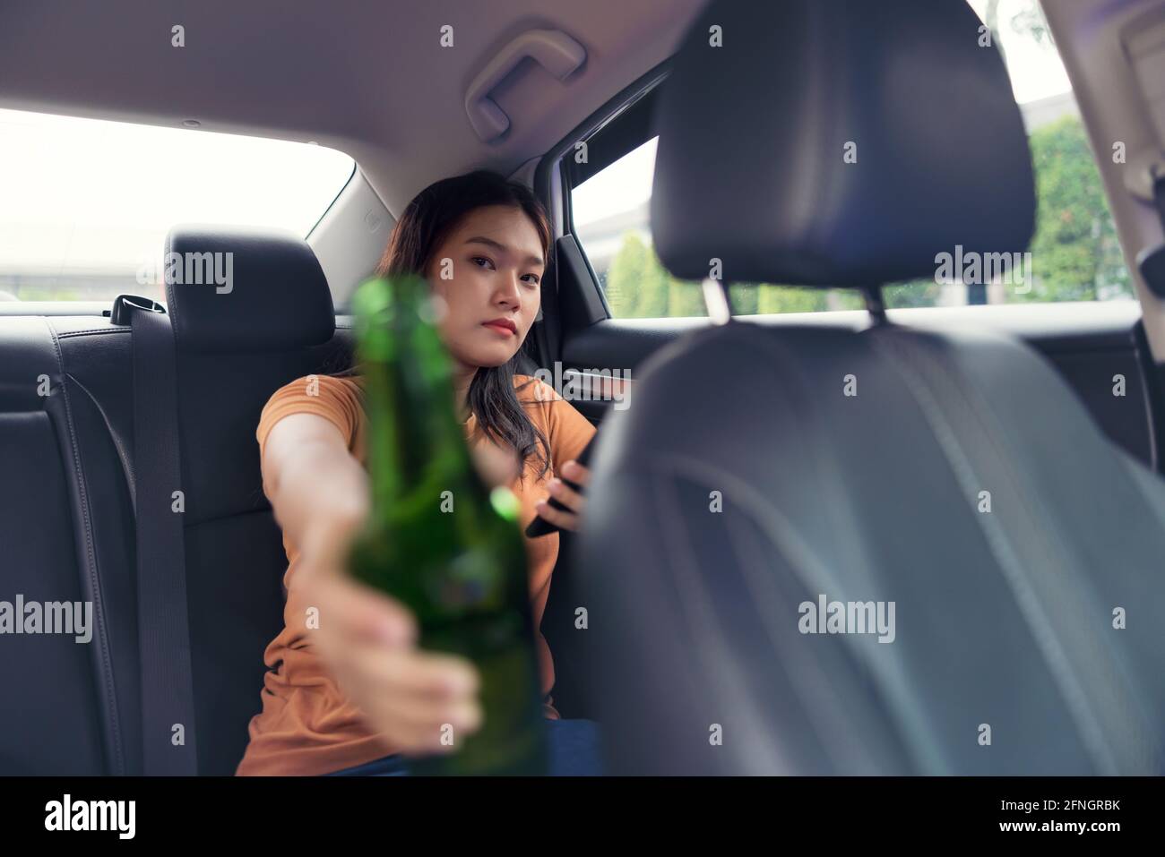Boire une bière à la bouteille dans la voiture, filles boire de l'alcool Banque D'Images