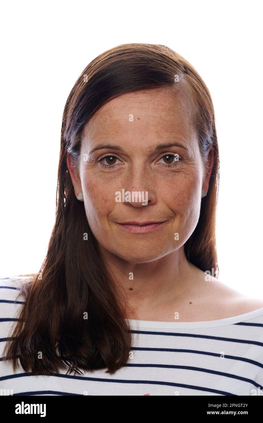 Femme d'âge moyen avec un sourire chaleureux et calme et de longs cheveux bruns a balayé de près le côté au-dessus de son épaule vue de dessus isolée sur blanc Banque D'Images