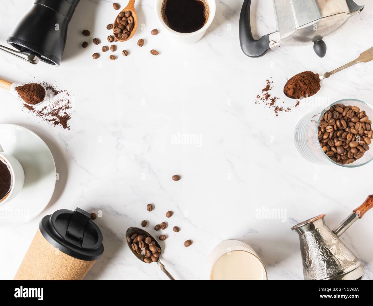 Cadre plat de pose de café, divers ustensiles pour faire du café et des tasses de café sur fond de marbre blanc. Concept du café. Vue de dessus. Copier l'espace Banque D'Images