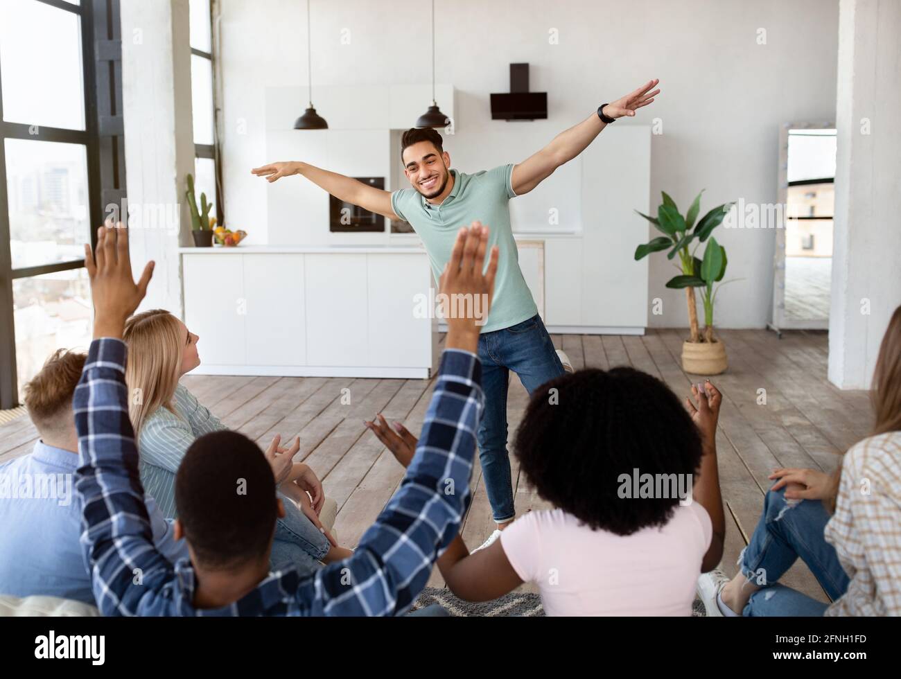 Drôle de jeunes divers amis jouant deviner qui jeu, rire, s'amuser ensemble à la maison Banque D'Images