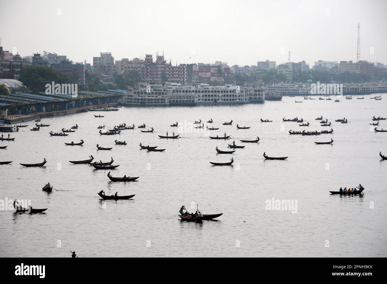 DHAKA, BANGLADESH – MAI : de petits bateaux en bois sont vus transportant des passagers pour traverser le fleuve Buriganga à Dhaka, au Bangladesh, le 2021 mai. Banque D'Images