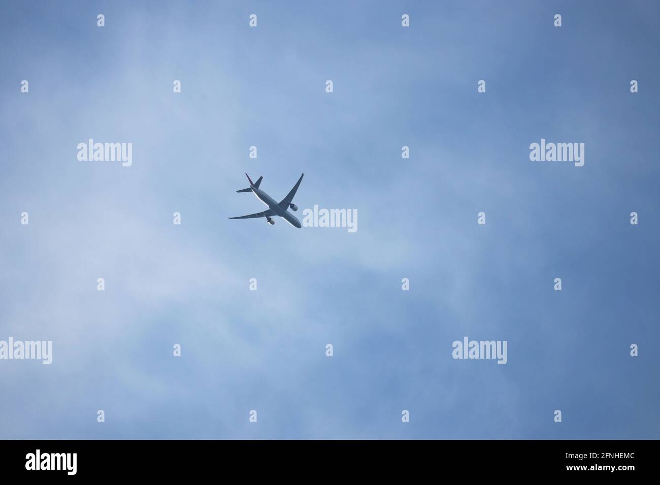 Avion volant dans le ciel bleu sur fond de nuages blancs. Concept d'avion commercial à deux moteurs, de turbulence et de déplacement Banque D'Images